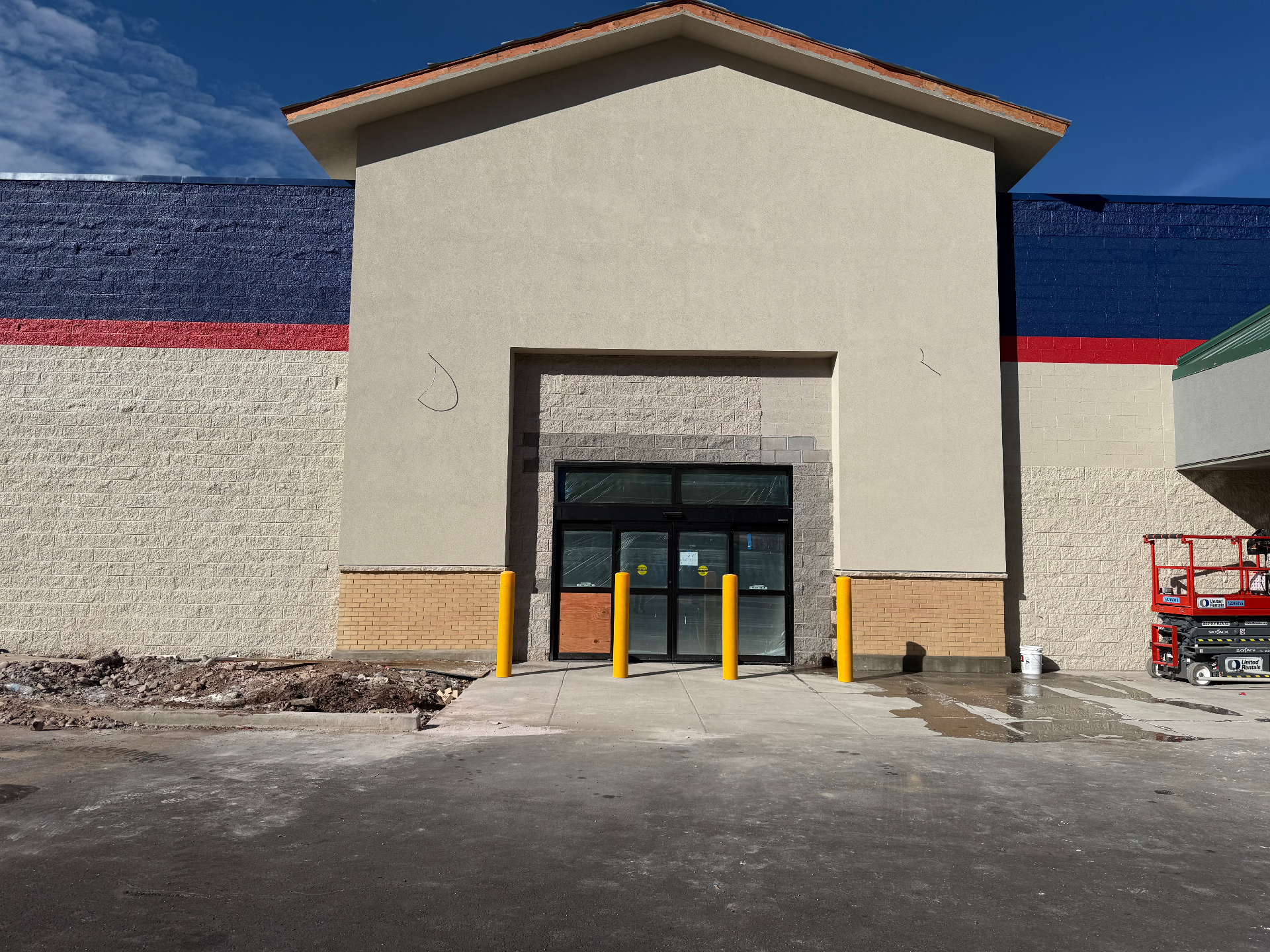 Commercial stucco entry tower with brick wainscot and bollards