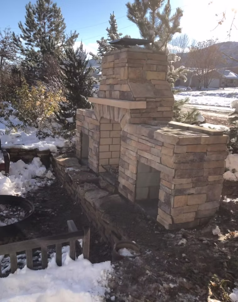 Outdoor living space with patio, fire pit, and stone features