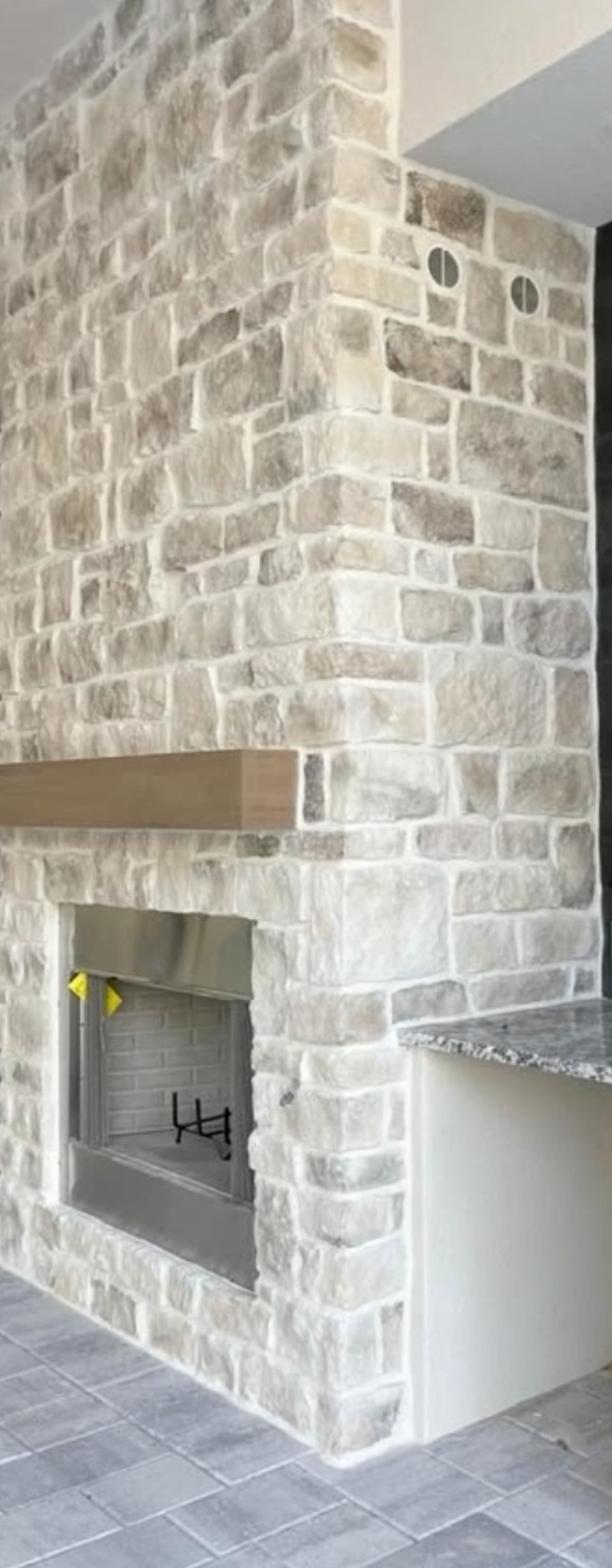 Indoor-outdoor natural stone fireplace with chiseled stone surround