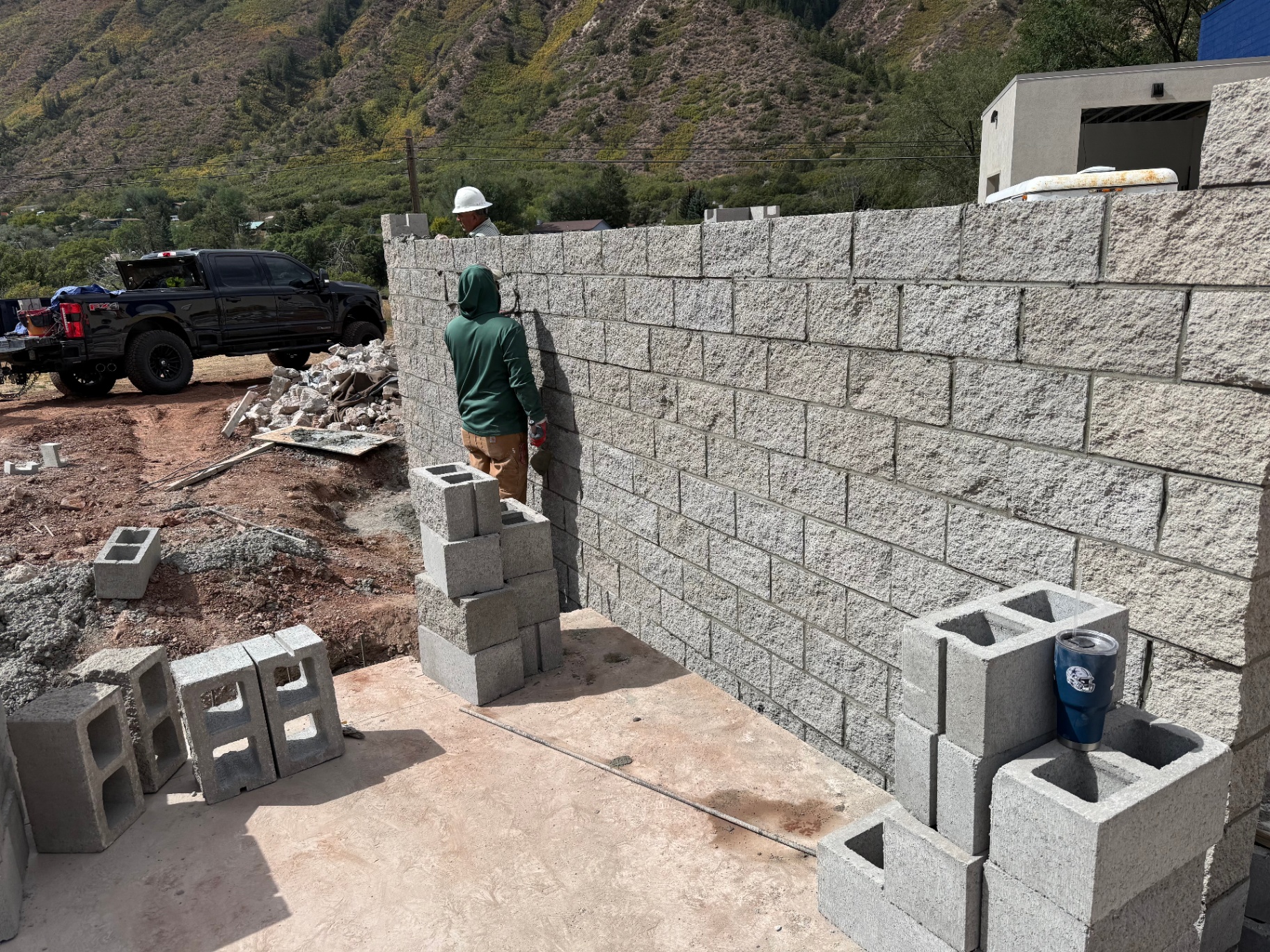 Mason laying split-face block wall on a mountain-side Colorado project
